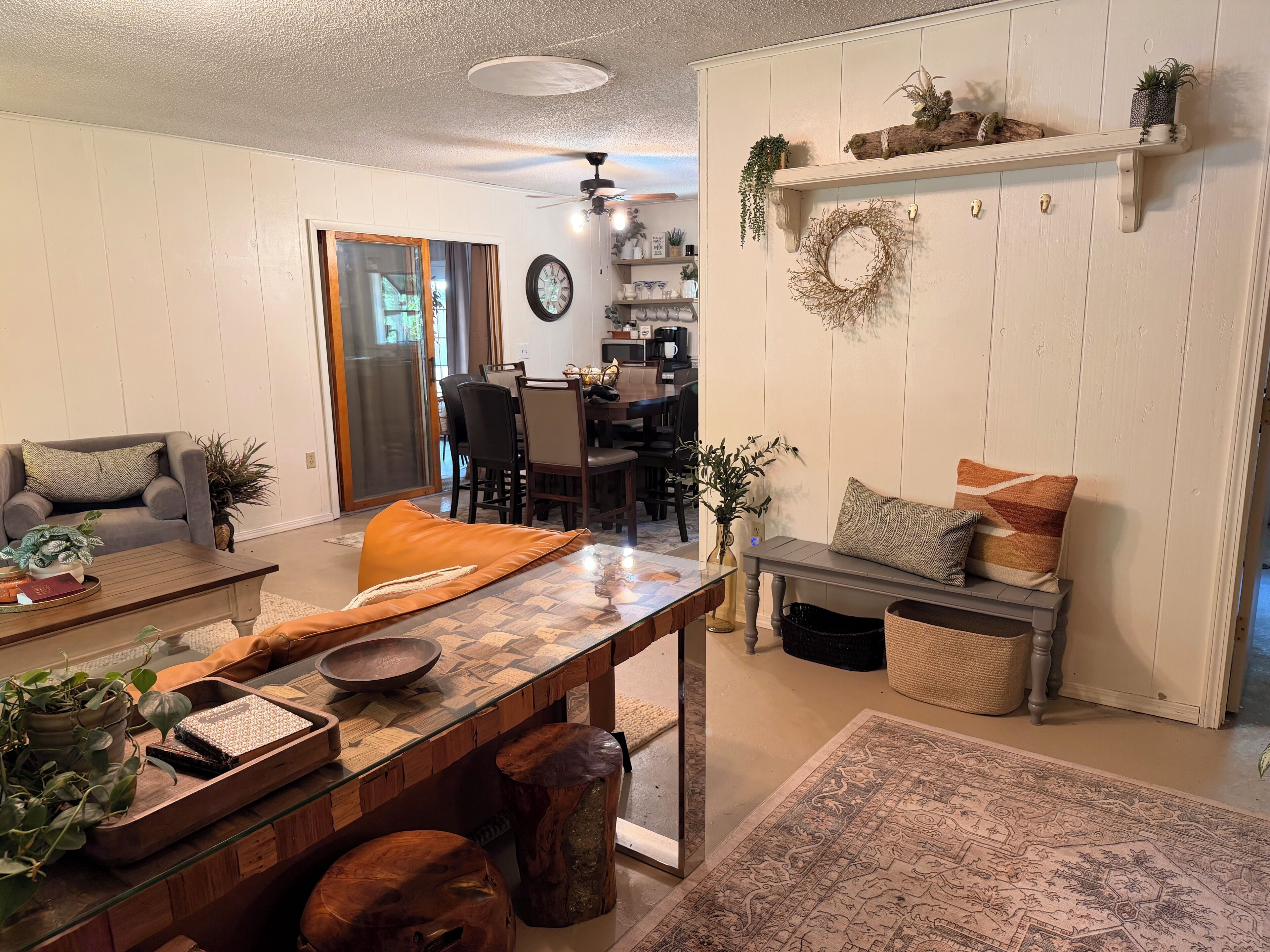 A living room with a dining area, a fireplace, and a kitchen in the background.