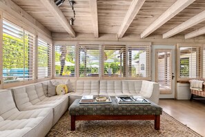 A spacious living room with a large sectional sofa, a wooden ceiling, and large windows with blinds. - Private Oasis Retreat (Palm Springs)