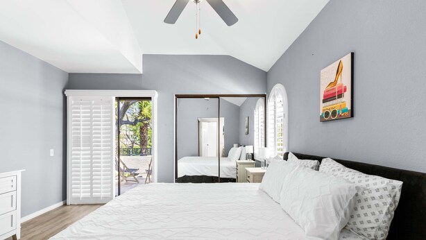 A bedroom with a bed, a nightstand, a dresser, and a window with blinds. - South Cherokee in Palm Springs (Palm Springs)