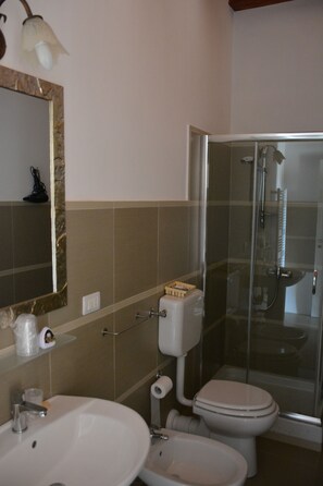 A bathroom with a sink, toilet, and shower.