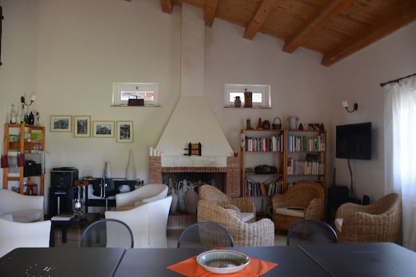 A living room with a fireplace, bookshelves, and a television.