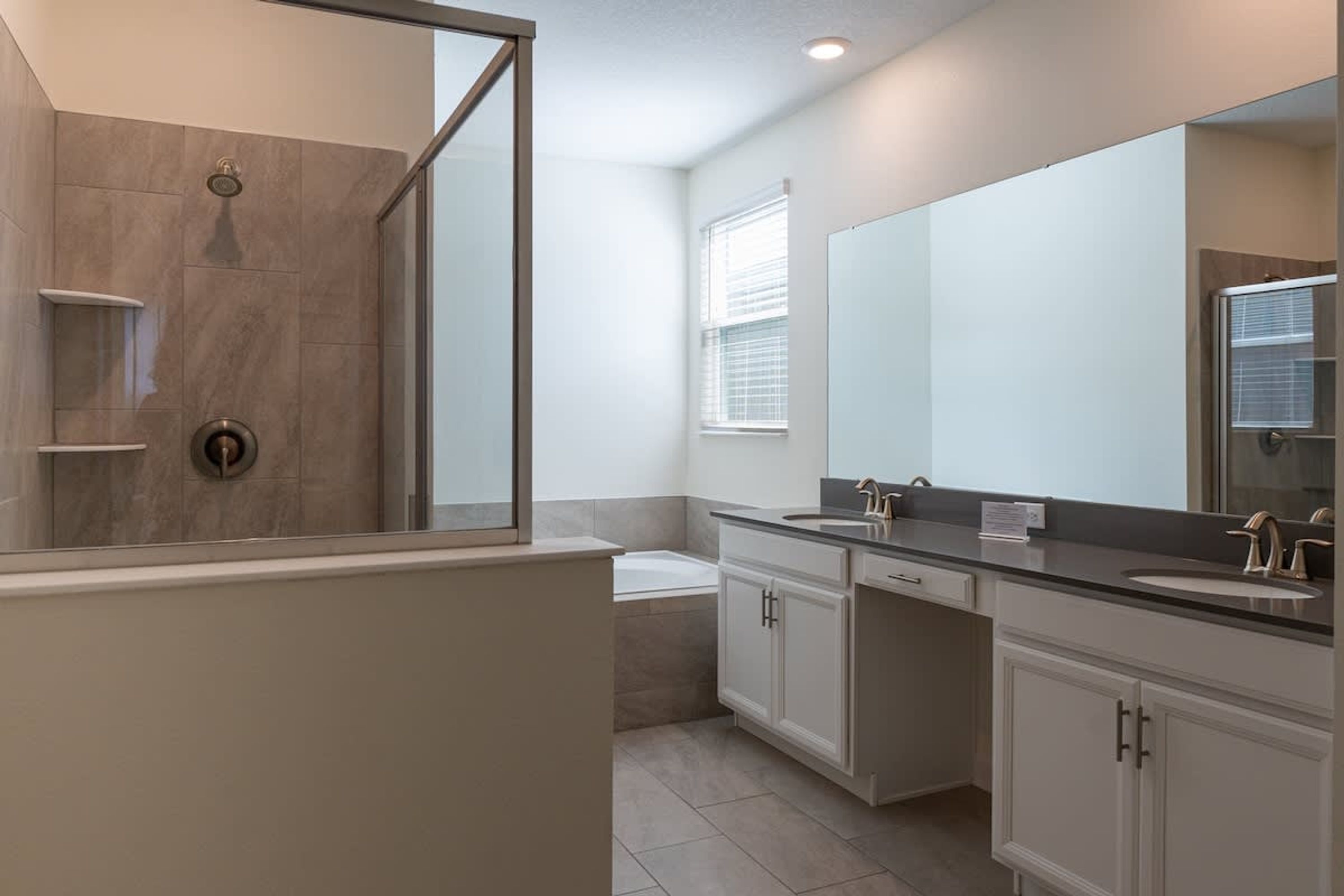 Une salle de bain moderne équipée d’une douche, d’une baignoire et de deux lavabos.