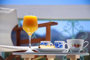 A table with a glass of orange juice, a cup, and a plate with toast. - Apartment Simply 303 - Ammoudara Sandy Retreat (Malevizi)