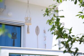 Ein Zimmer mit großem Fenster, einer Pendelleuchte und Wanddekorationen.