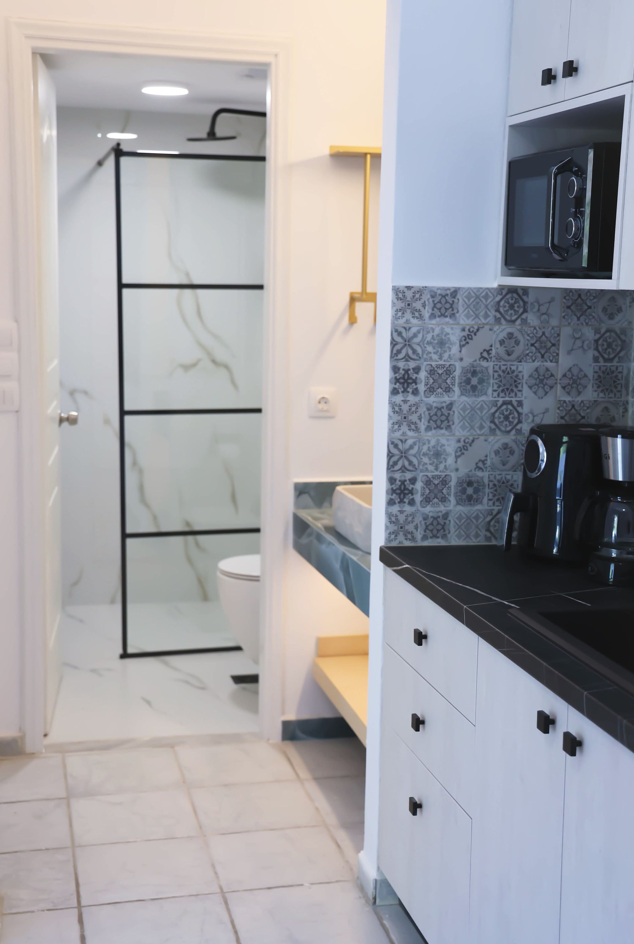 Un baño con inodoro blanco, ducha y suelo de baldosas.