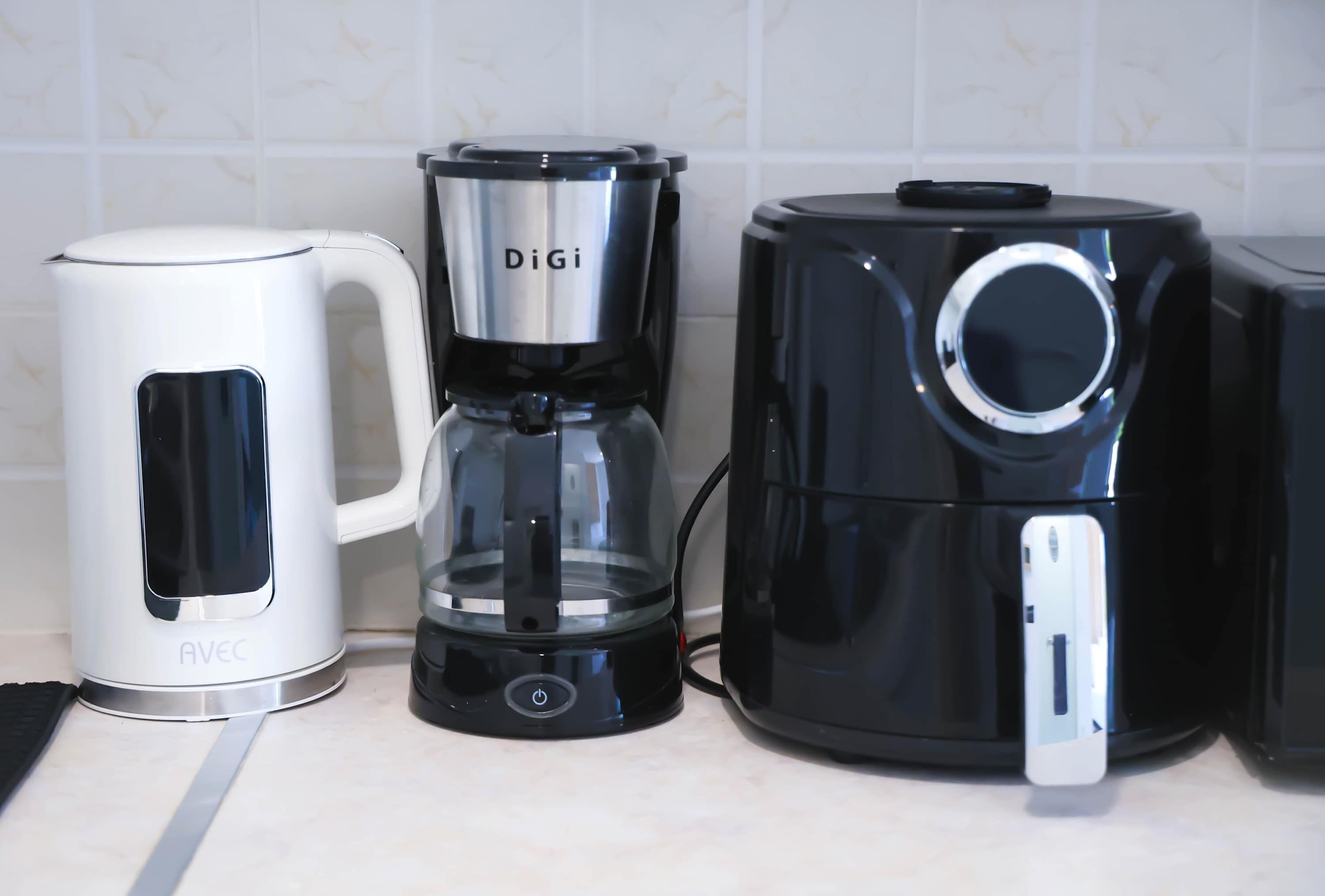 Tres cafeteras sobre una encimera de cocina.