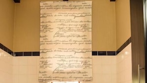 Un baño con una bañera, un lavamanos y un gran papel con texto en la pared.