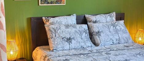 A bed with floral-patterned bedding, a dark headboard, and two bedside lamps.