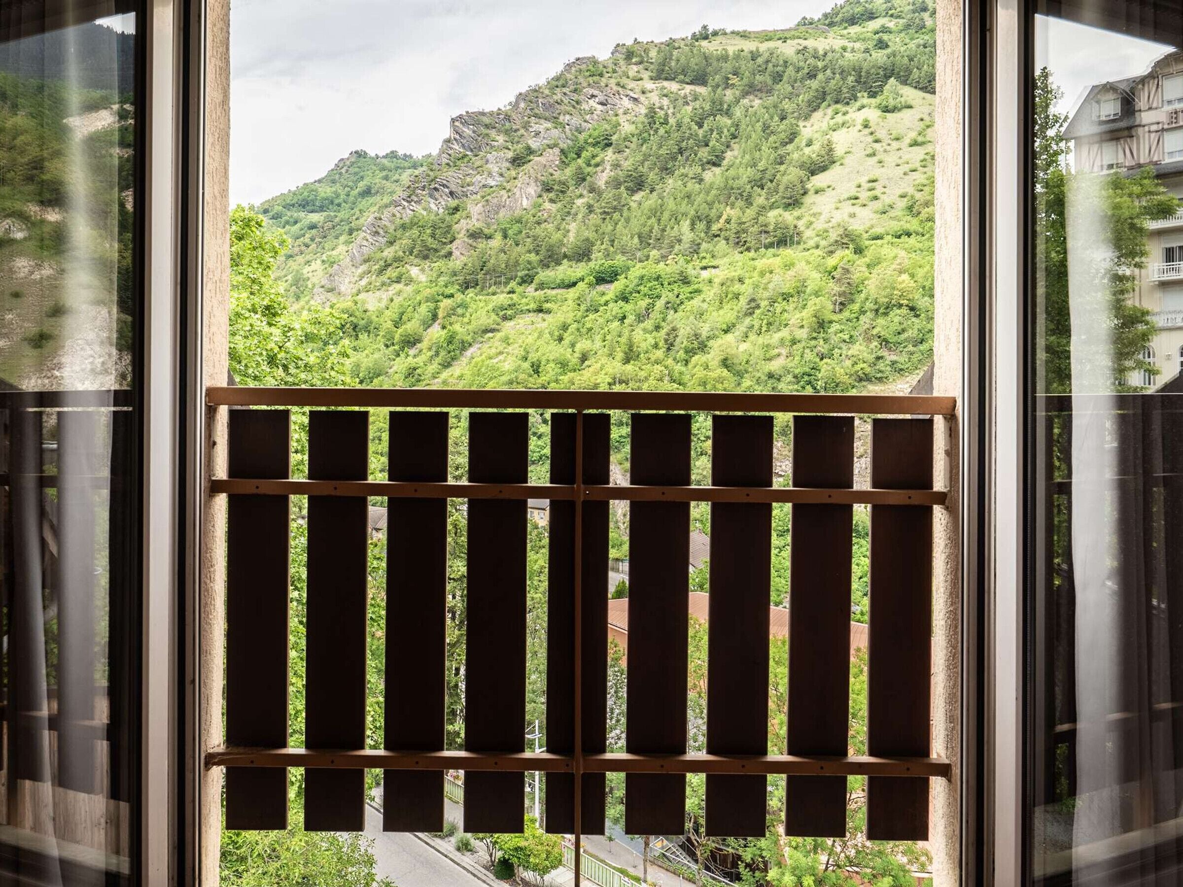 A balcony with a view of a mountainous landscape.