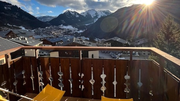 A mountain view from a balcony with wooden railings and a yellow chair. - Comfortable duplex - 6 guests (Châtel)