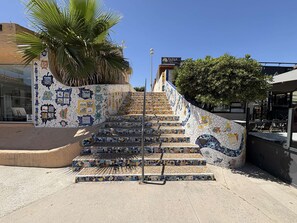Eine Treppe mit Mosaikfliesen, die zu einem Gebäude führt.