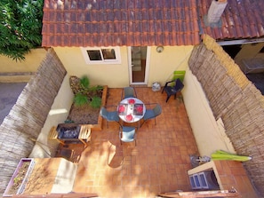 A patio with a table and chairs, a small window, and a door. - Calm lodge near port - 6 guests (Canet-en-Roussillon)