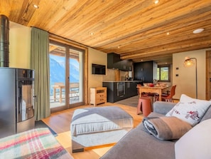 A modern interior with a wooden ceiling, a kitchen area, a dining space, and a sofa with a view of mountains. - Spacious apartment near center - 6 guests (Châtel)