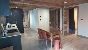 A modern kitchen with a dining area, wooden ceiling, and a large table with chairs. - Spacious apartment near center - 6 guests (Châtel)