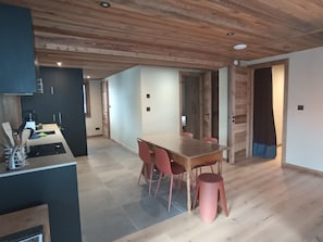 Eine moderne Küche mit Essbereich, Holzboden und einem großen Tisch mit Stühlen.