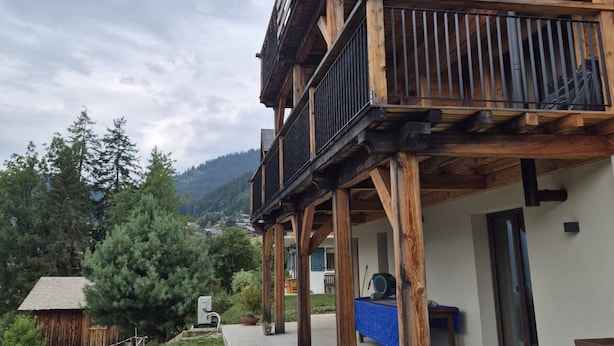 A wooden building with a balcony, a small shed, and a mountain in the background. - Spacious apartment near center - 6 guests (Châtel)