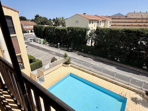 Ein Poolbereich mit Blick auf eine Wohnstraße und Gebäude im Hintergrund.
