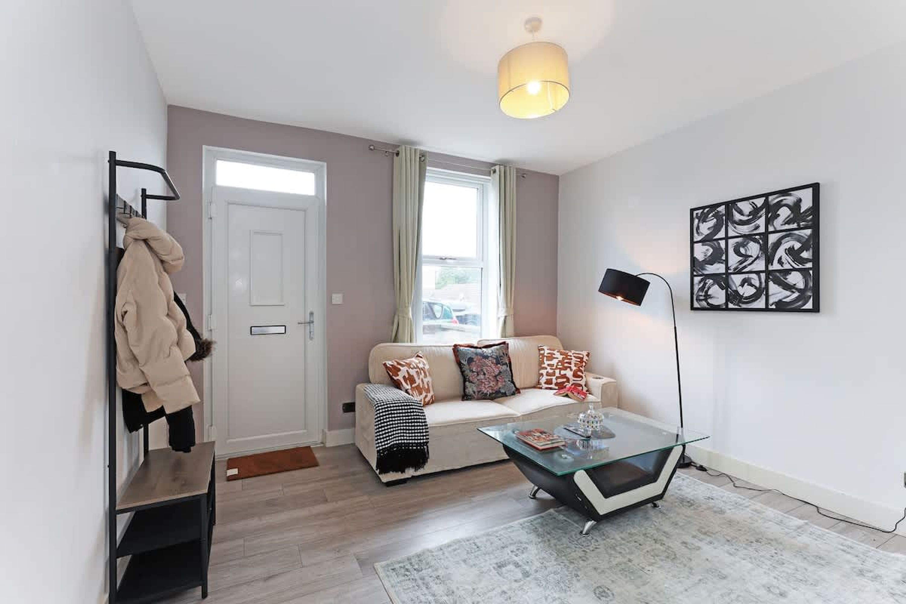 Ein modernes Wohnzimmer mit einer Couch, einem Couchtisch und Kunstwerken an der Wand.
