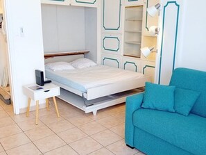 Ein Schlafzimmer mit einem Bett, einem Schreibtisch, einem Stuhl und einem Kleiderschrank.