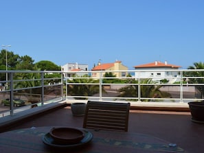 Ein Balkon mit Blick auf Gebäude und Palmen.