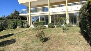 Un edificio moderno de dos pisos con techo plano, ventanas amplias y un balcón cubierto.