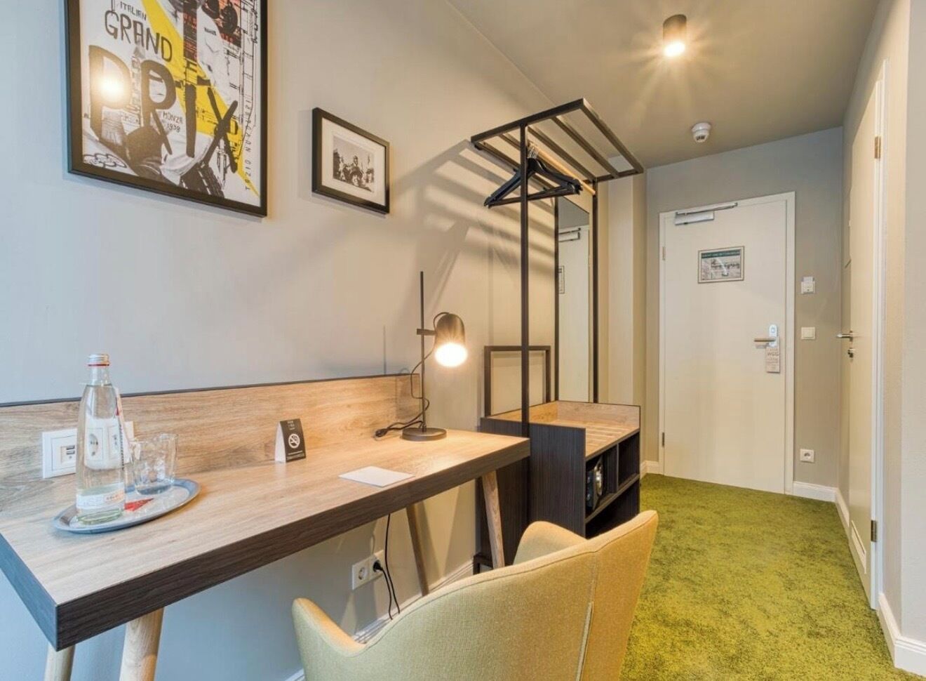 Une chambre d’hôtel équipée d’un bureau, d’une chaise, d’une lampe et d’un lit.