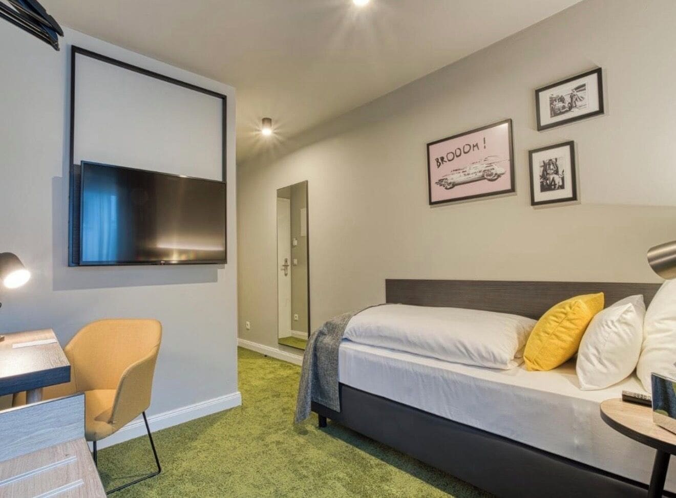 Un dormitorio con cama, escritorio, silla y ducha.
