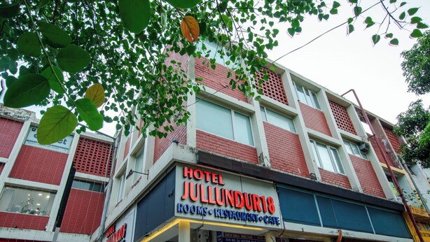 Un hotel llamado 'Hotel Jullundur18' con un letrero que indica habitaciones, restaurante y cafetería.