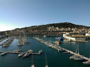 A marina with numerous boats docked, a harbor with buildings, and a hillside in the background. - Spacious T2, AC, sea view - 5 guests (Sète)