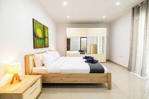 Ein modernes Schlafzimmer mit einem Holzbett, einem Nachttisch, einer Lampe, einem Spiegel und Bildern an der Wand.
