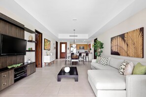 A modern living room with a TV, sofa, coffee table, and artwork. - Effortless Elegance - Fairway Meets the Lake (Río Grande)