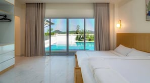 Ein Hotelzimmer mit Bett, Blick auf einen Swimmingpool und einem Balkon.