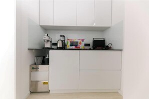 A compact kitchenette with a coffee maker, kettle, and a colorful container. - Villa Korina (Primošten)