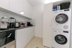 A compact kitchen with a coffee maker, kettle, toaster, and a washing machine. - Villa Korina (Primošten)