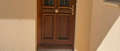 A wooden door with a glass panel, a metal handle, and a keyhole.