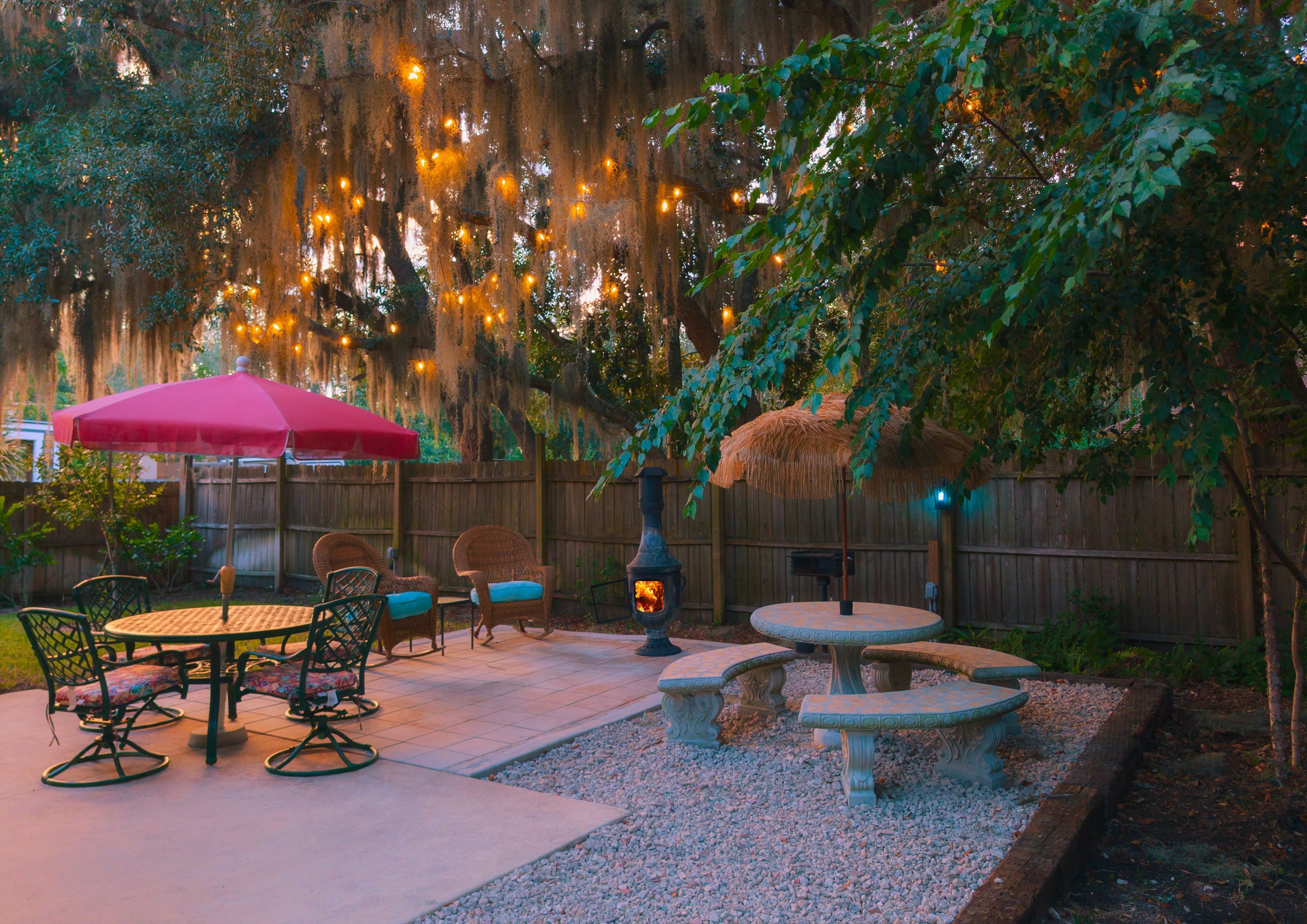 A patio with outdoor furniture, a fire pit, and string lights.