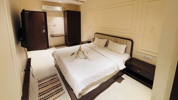 Quarto com cama, guarda-roupa, televisão e ventoinha no teto.