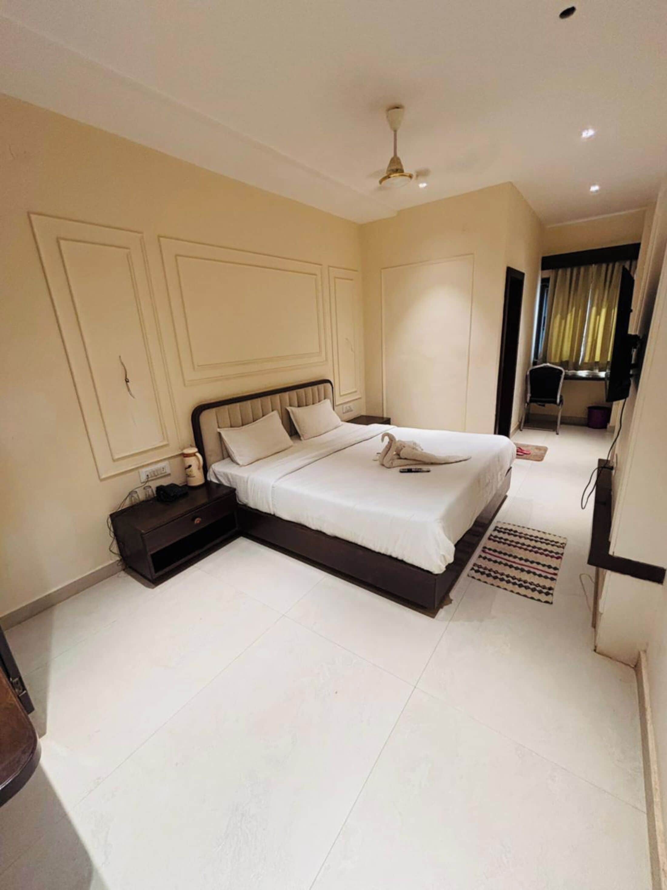 A bedroom with a bed, bedside tables, a ceiling fan, and a window with curtains.