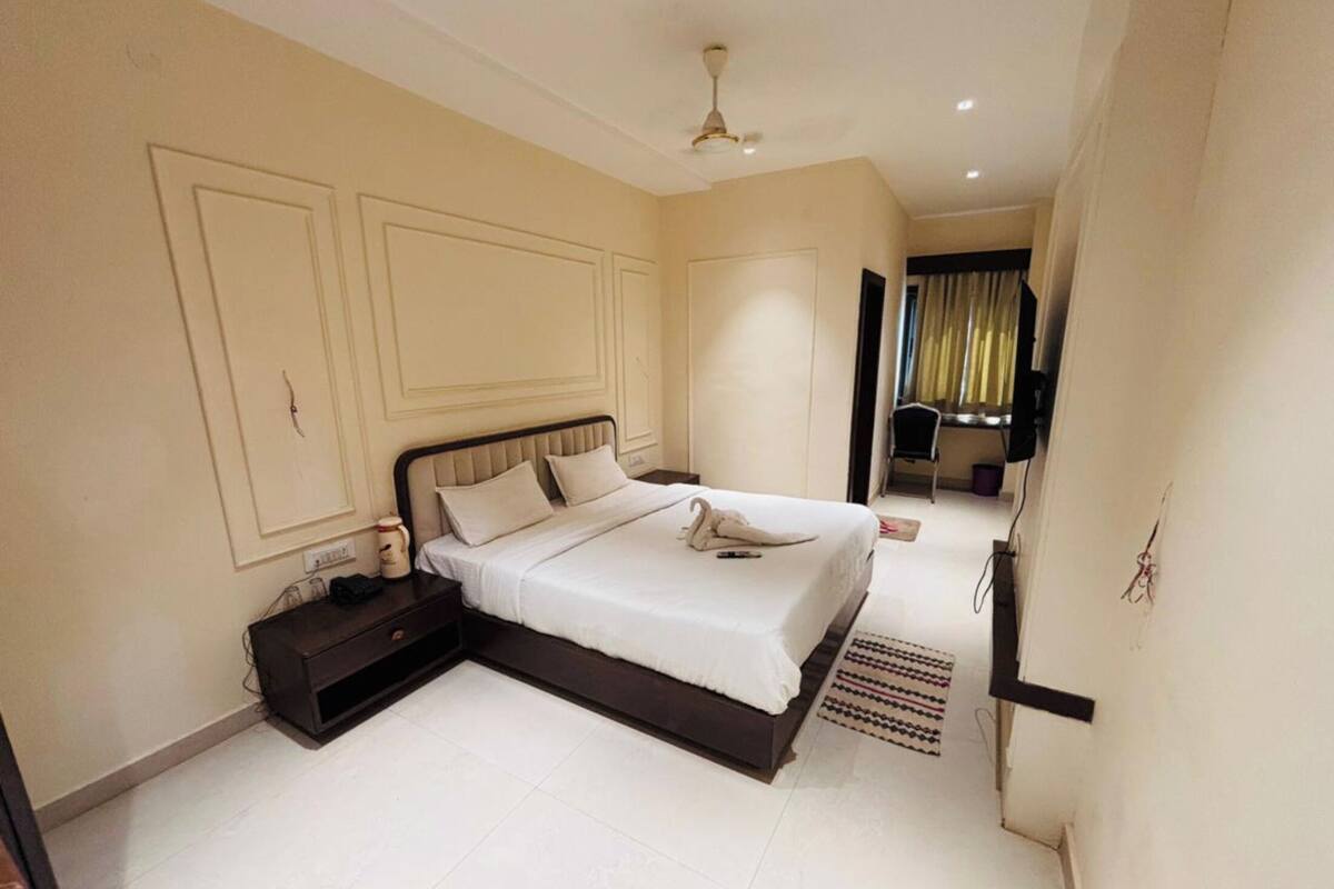 A bedroom with a bed, nightstand, and a ceiling fan.