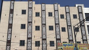 Un edificio de varios pisos con un cartel que dice 'HOTEL CORPORATE' y paneles verticales decorativos.