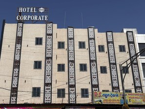 A multi-story building with a sign reading 'HOTEL CORPORATE' and decorative vertical panels. - Corporate Hotel Shivpuri (Shivpuri)