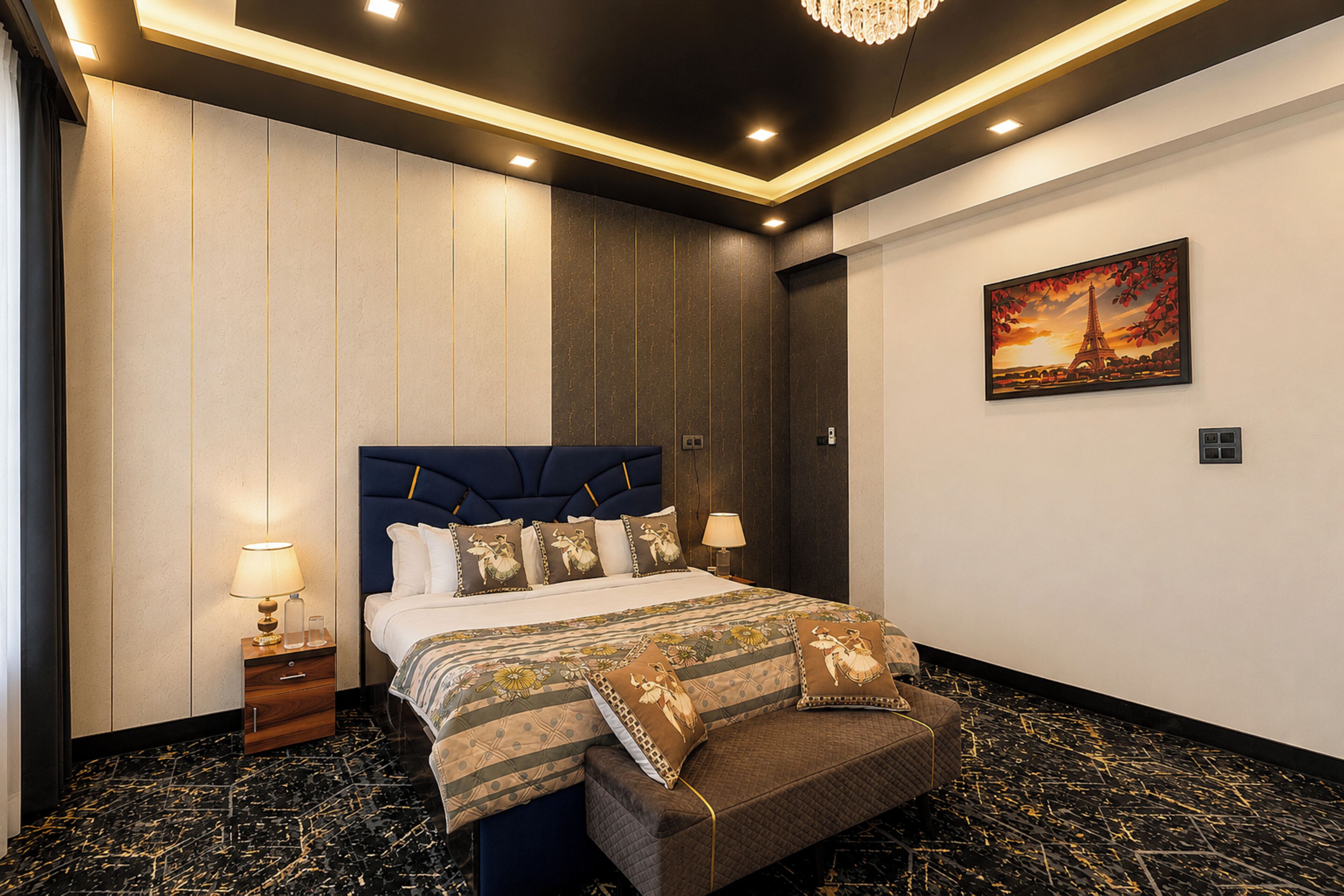 A hotel room with a bed, nightstands, a chandelier, a painting, and a marble floor.