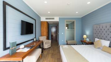 Une chambre d’hôtel équipée d’un lit, d’un bureau, d’une chaise, d’une télévision et d’un miroir.