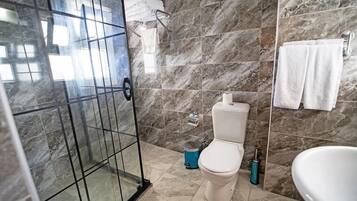 Une salle de bain avec une douche à parois de verre, des toilettes et une baignoire.
