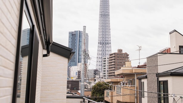Un immeuble de grande hauteur, doté d’une tour imposante, d’une architecture moderne et d’un balcon agrémenté d’une balustrade.