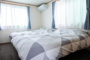 A hotel room with a bed, air conditioning unit, and curtains. - Newly Built Villa * 8-minute walk from Skytree-Oshiage Station * 3-minute tram ride to Asakusa * Direct access to Haneda Airport, Narita Airport, and Disney (墨田区)