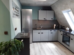 A modern kitchen with a built-in dishwasher, a sink, and a window. - Apartment 'Otto' in Nürnberg (Nuremberg)