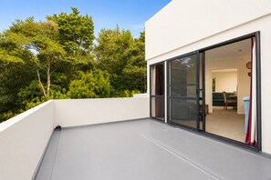Un edificio moderno con techo plano, amplias puertas correderas de vidrio y vistas a un paisaje verde exuberante.