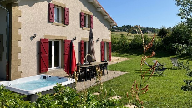 Une maison avec piscine, un espace extérieur aménagé et une vue sur la campagne.