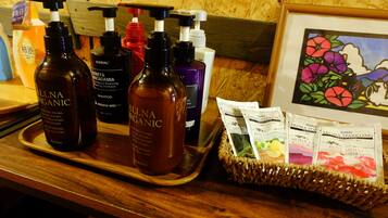 A tray with various organic shampoo bottles and a basket of scented sachets.